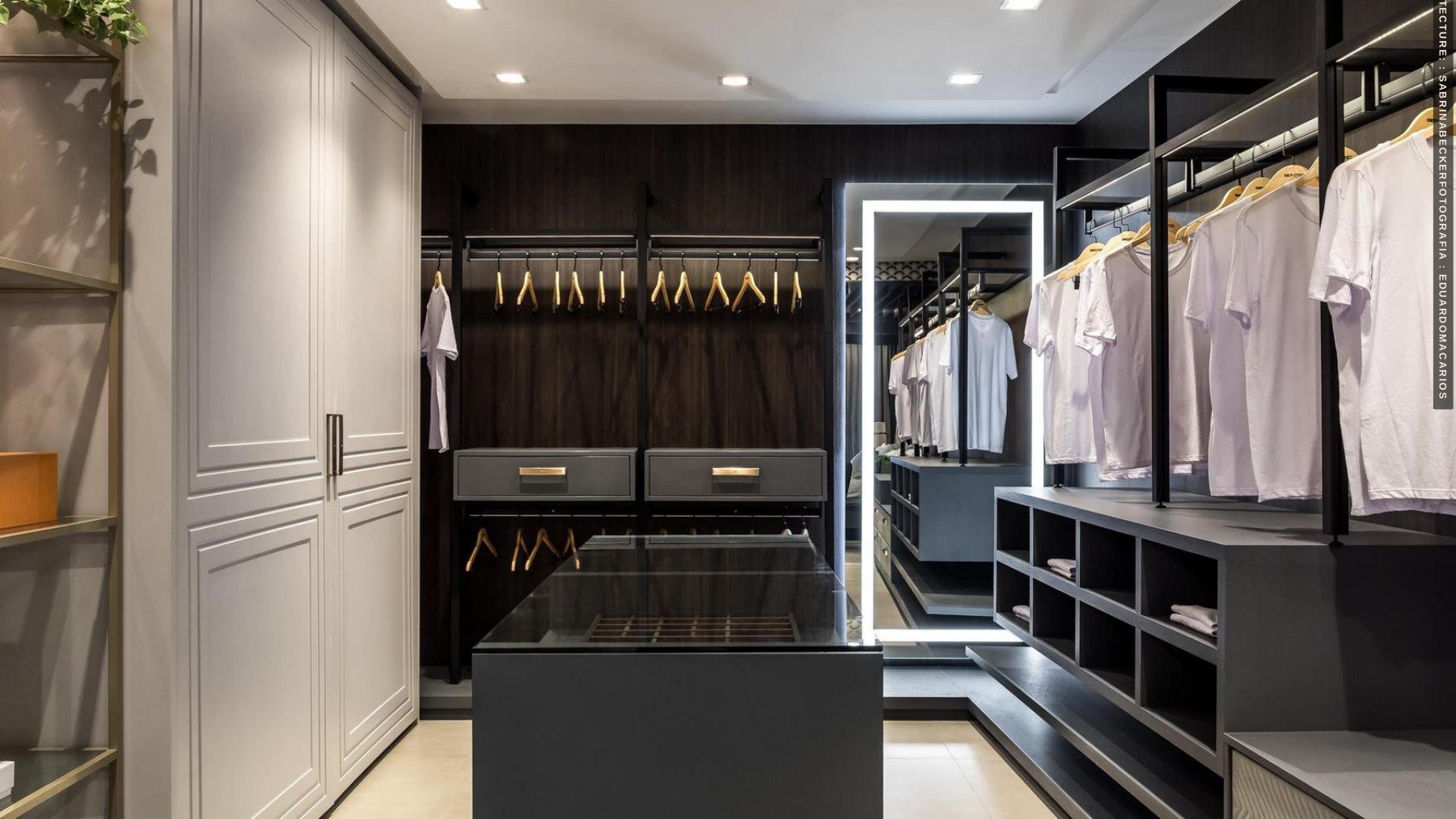 Walk-in wardrobe with dark cabinetry and illuminated storage