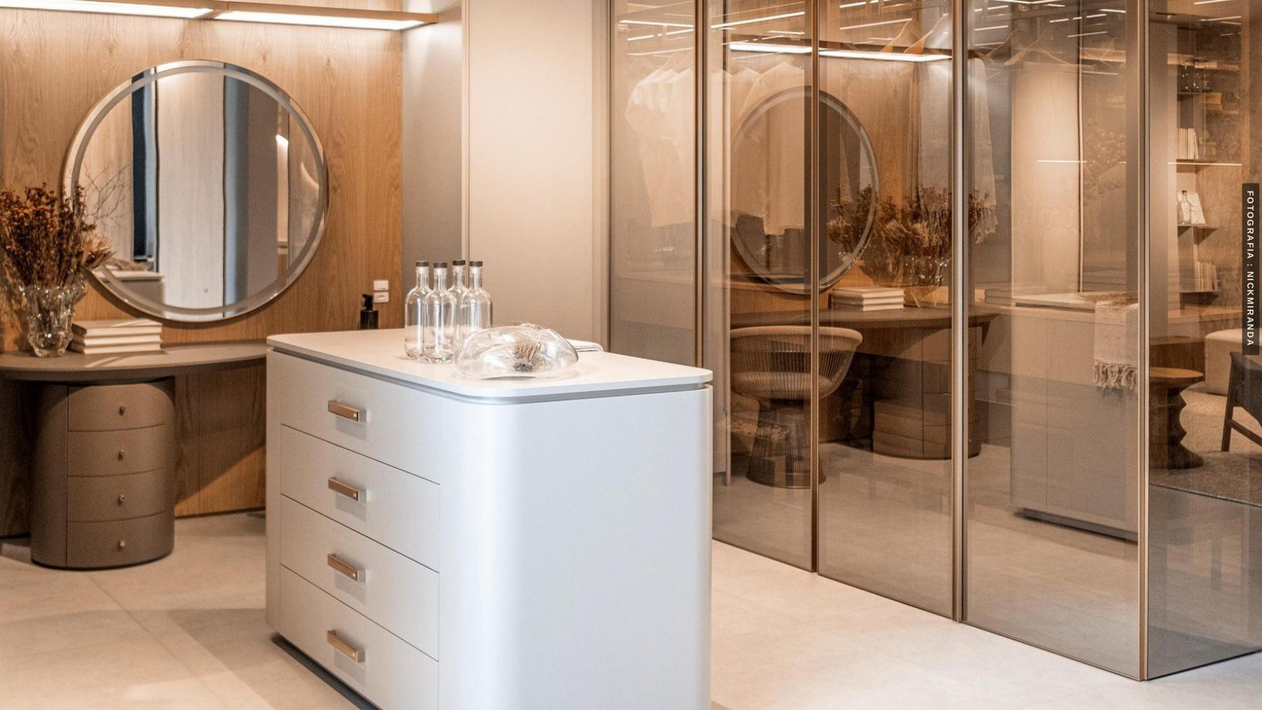 Dressing area with a vanity and glass-fronted wardrobe