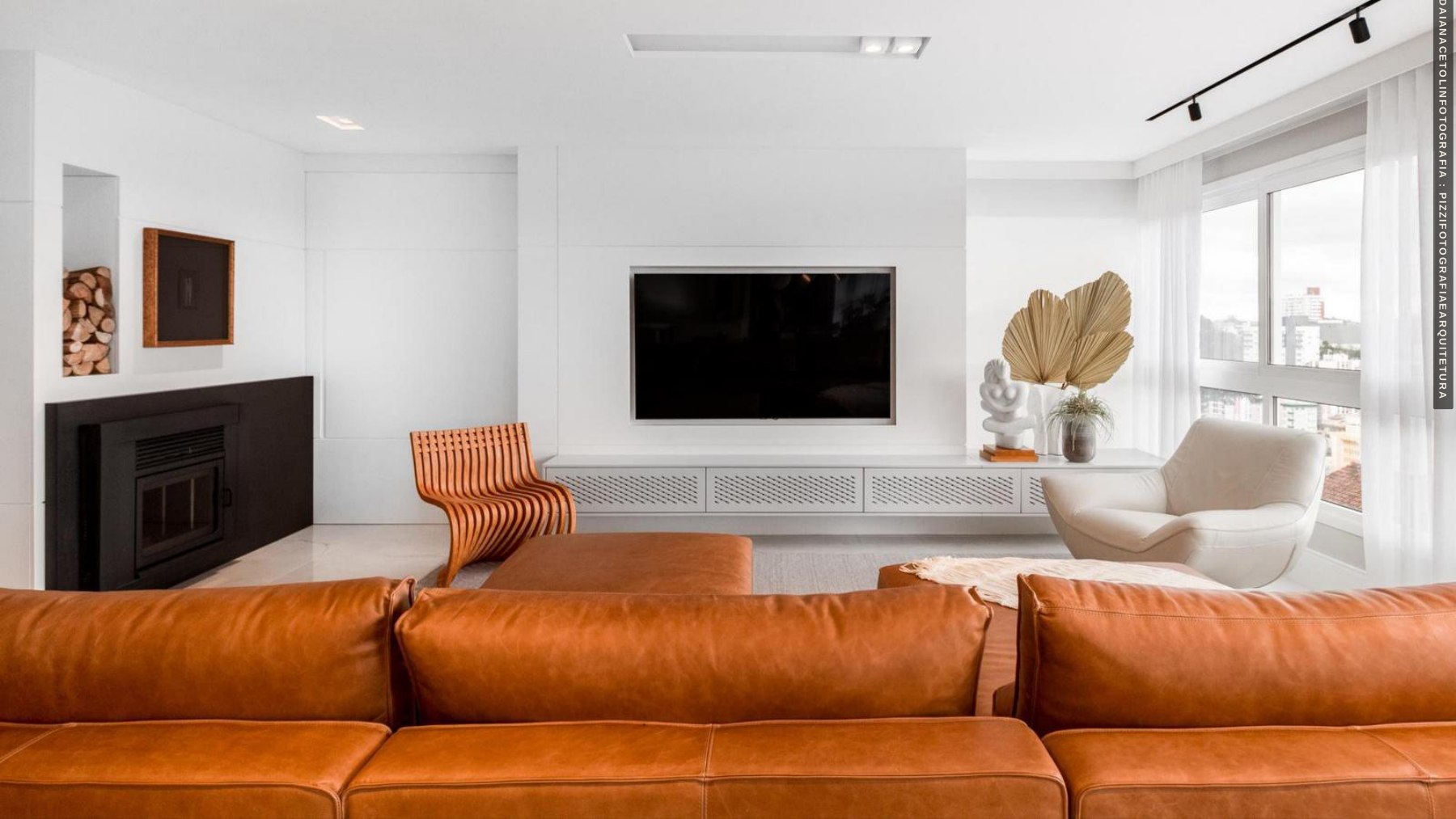 Bright living room with an orange sofa and integrated cabinetry